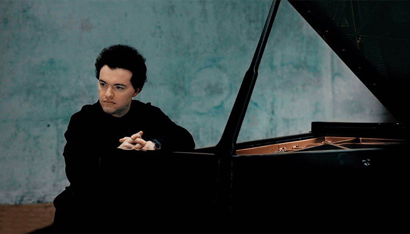 Evgeny Kissin With Fingers Intertwined Sitting At The Piano