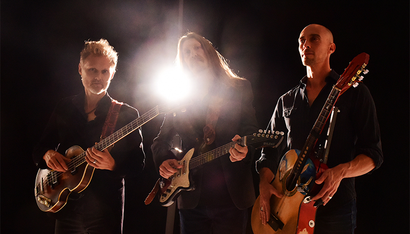 The Wood Brothers Backlit And Holding Their Instruments