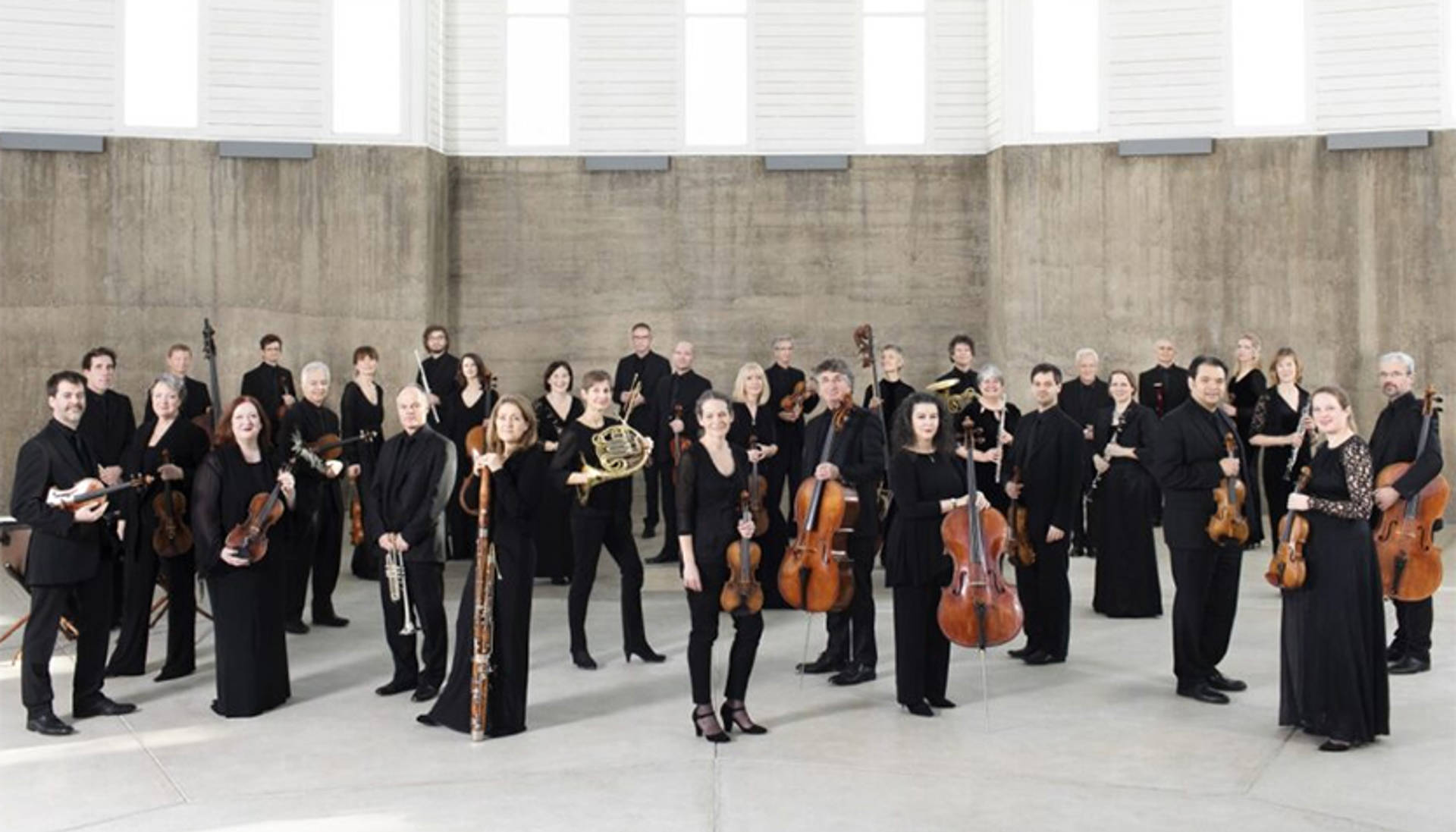 Academy Of St Martin In The Fields Orchestra Members Standing In Front Of A Building With Their Instruments