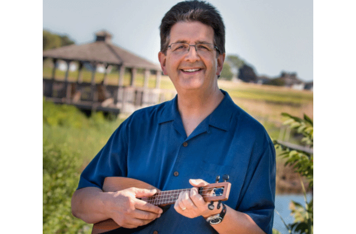 Jim Beloff In Front Of A Lake And Gazebo With His Ukulele