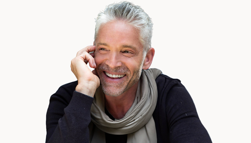 Dave Koz Wearing A Dark Sweater And Gray Scarf While Smiling On A White Background