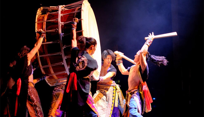 Yamato Performers Holding Up A Large Drum For A Drummer