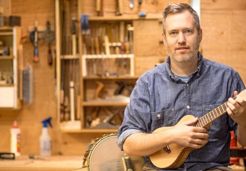 Aaron Keim Sitting In A Woodshop With His Ukulele